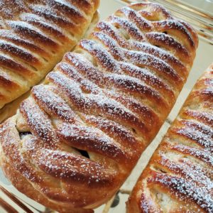 three danish pastry braids with powdered sugar on top