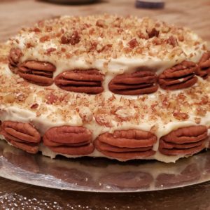 two tier carrot cake with pecans surrounding the outside