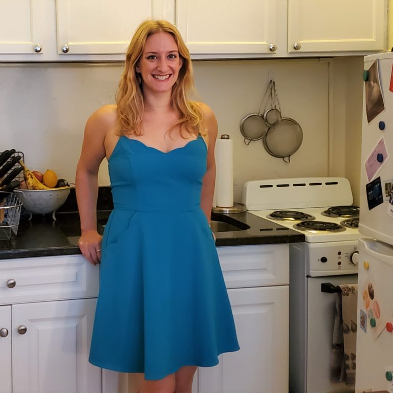 Joey Rockman standing in the kitchen wearing a blue dress