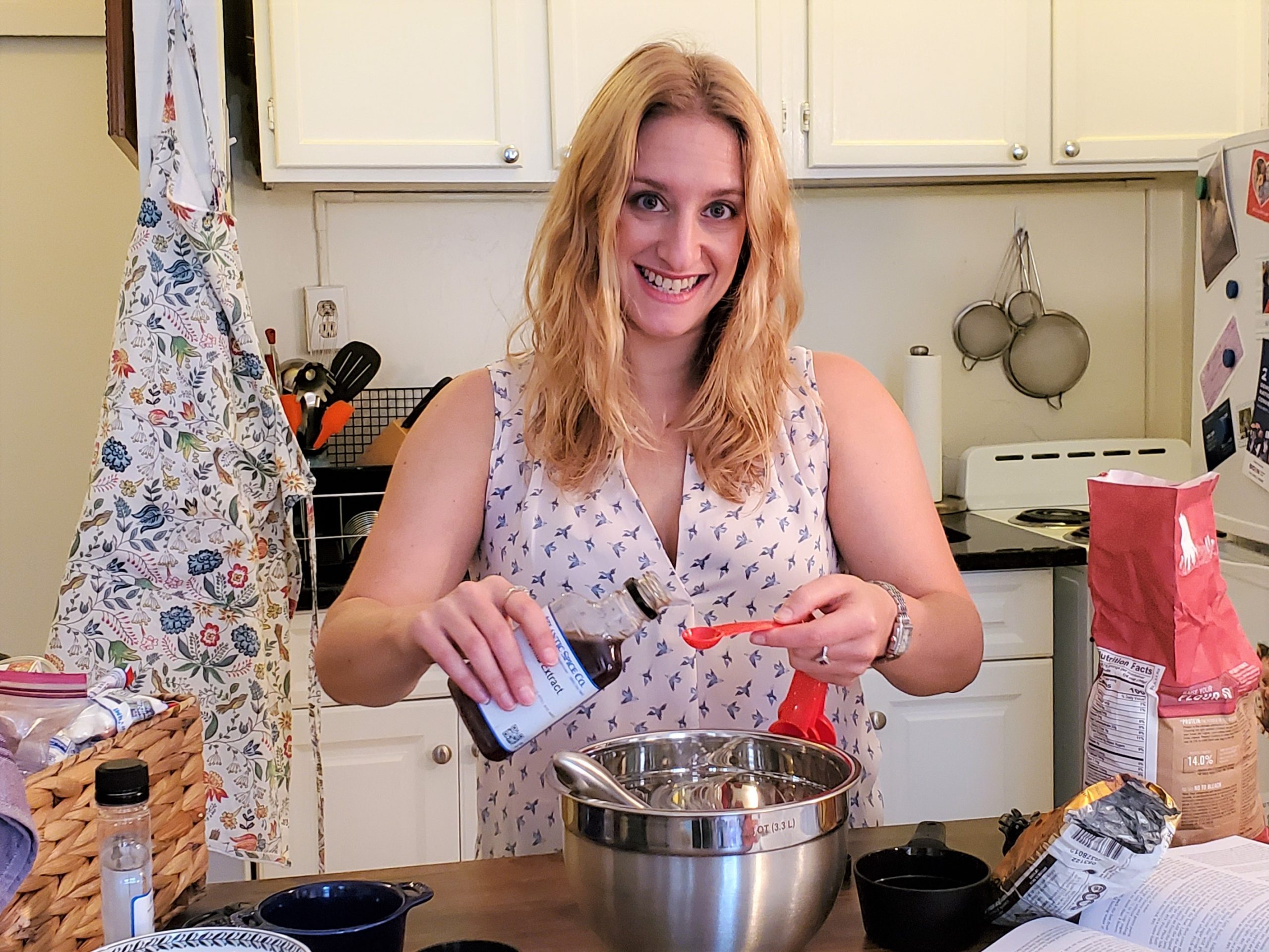 joey rockman in her kitchen pouring out vanilla extract surrounded by baking ingredients