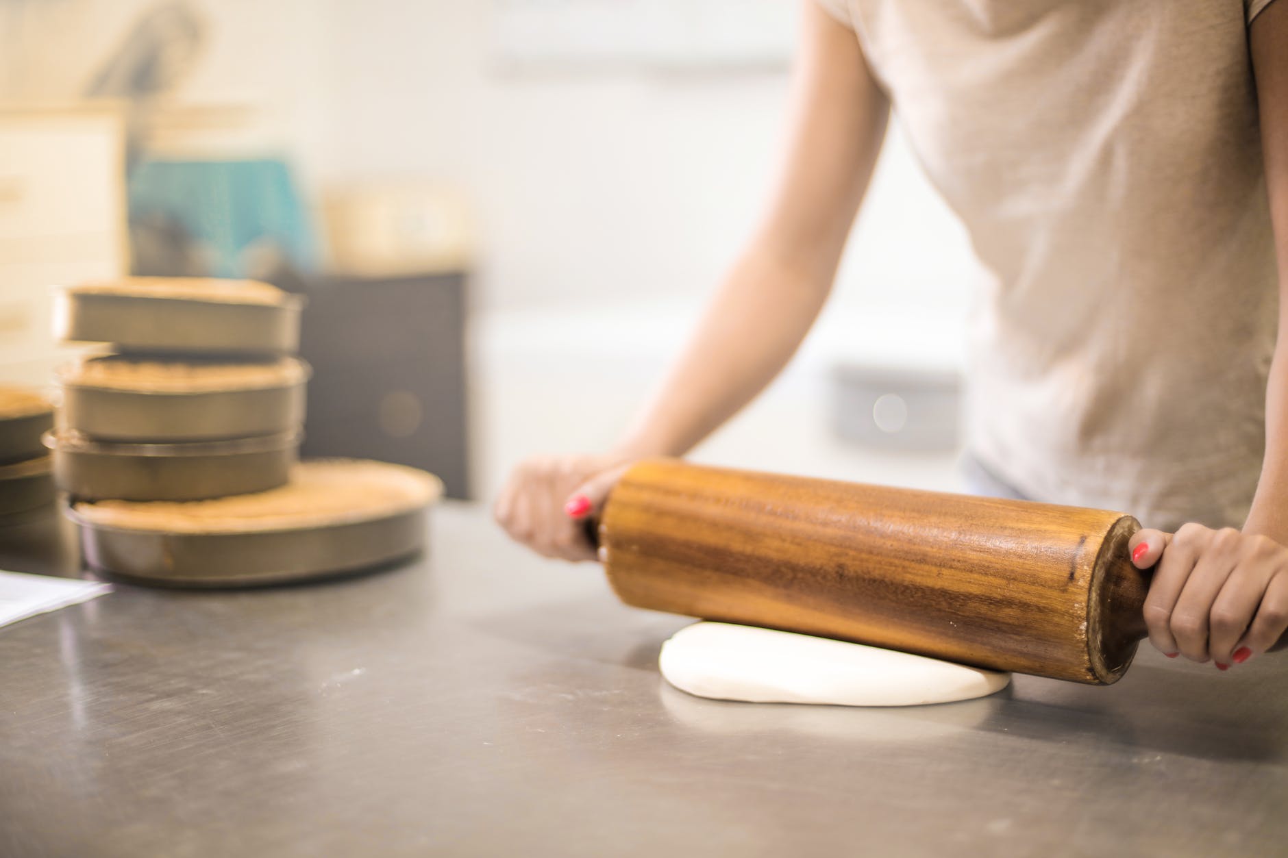 baker rolling out dough on a counter