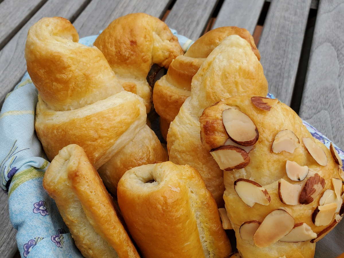 croissants sitting in a basket on a wooden table